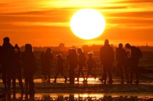Brighton, England Beach goers view the sunset along the shoreline