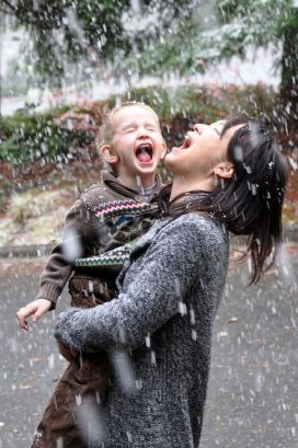 mother and child enjoying the rain