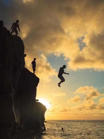 USA, Hawaii, Oahu, North Shore, Waimea Bay, Divers Jumping Off Cliff Photographic Print by Michele Falzone | Art_com